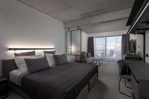 una camera da letto con un letto, una scrivania e una finestra di Essence Suites Downtown Suites - Adults Only a Città di Rodi