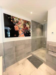 a bathroom with a painting of a woman on the wall at Lichtdurchflutetes Design - Appartement Gütersloh - 90 qm in Gütersloh