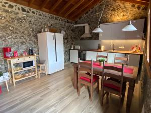 a kitchen with a table and a white refrigerator at Casa Sol in Hermigua +15 photos