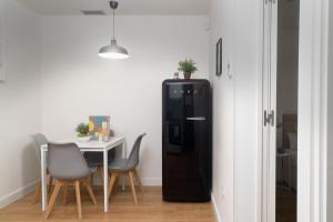 una nevera negra en un comedor con mesa en Vibe Apartments by Olala Homes, en Hospitalet de Llobregat