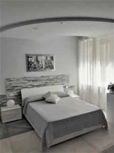 una camera con un grande letto e un muro di mattoni di La Cittadella10 a Torino
