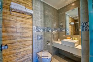 a bathroom with a sink and a toilet and a mirror at Island Boutique Hotel in Rhodes Town