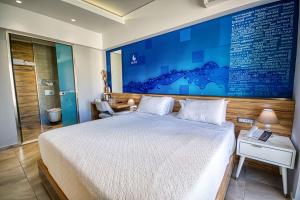 a bedroom with a bed and a blue painting on the wall at Island Boutique Hotel in Rhodes Town