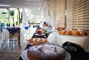 stół z różnymi rodzajami wypieków i ciast w obiekcie Park Oasi Resort w mieście Zambrone