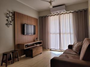 un soggiorno con un divano e una TV di Olímpia Temporada Cond. Villagio a Olímpia