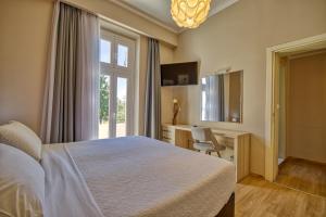 a bedroom with a bed and a desk and a window at Island Boutique Hotel in Rhodes Town
