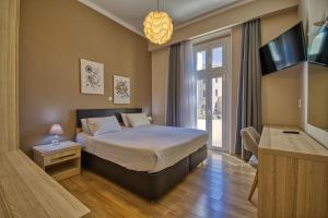 a bedroom with a bed and a tv and a window at Island Boutique Hotel in Rhodes Town