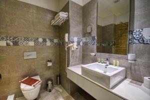 a bathroom with a sink and a toilet and a mirror at Island Boutique Hotel in Rhodes Town