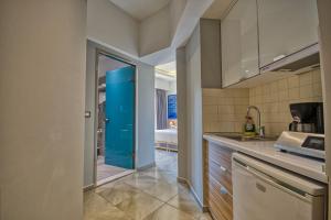 a kitchen with a sink and a blue door at Island Boutique Hotel in Rhodes Town