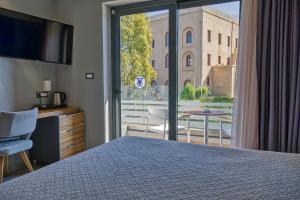 a bedroom with a bed and a balcony with a view at Island Boutique Hotel in Rhodes Town