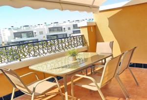 uma mesa e cadeiras numa varanda com vista em Apartment with large roof solarium em Orihuela Costa