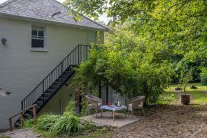 a patio with two chairs and a table next to a house at The Nook at Henge Estate in Salisbury