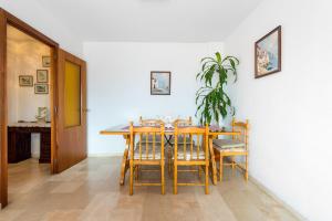 a dining room with a table and chairs and a plant at Fuengirola City Centre Apartment in Fuengirola