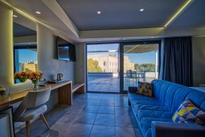 a living room with a blue couch and a balcony at Island Boutique Hotel in Rhodes Town