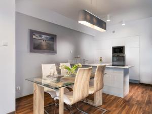 a kitchen with a table, chairs and a refrigerator at Atrium Apartamenty in Sarbinowo