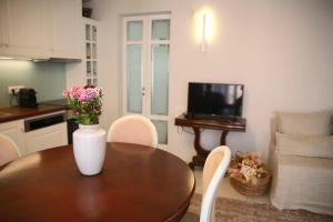a dining room table with a vase of flowers on it at Rimondi Residences Rethymno in Rethymno Town