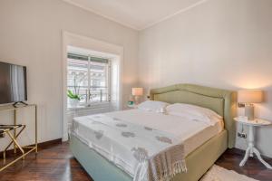 a bedroom with a bed and a television and a window at Imperiale Suites Milano in Milan