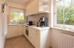 a kitchen with white cabinets and a window at Haus Gorch Fock Strasse in Westerland