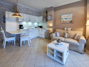 ein Wohnzimmer und eine Küche mit einem Sofa und einem Tisch in der Unterkunft Villa Fernsicht - Apt. 05 in Ostseebad Sellin