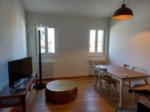 een woonkamer met een eettafel en een tv bij San Francesco in Lucca
