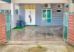 un garage vide avec une porte bleue et une table dans l'établissement Landed Rayyan Homestay Gong Badak Kuala Nerus Free Wifi Full Aircond, à Kampong Pengkalan Maras