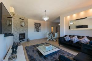 a living room with a black couch and a fireplace at Castillo Esmeralda in Alhaurín de la Torre