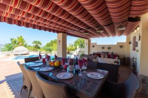 a table with plates and glasses on a patio at Castillo Esmeralda in Alhaurín de la Torre