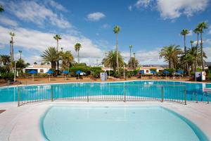 una gran piscina con palmeras en el fondo en Las Vegas Golf 316, en Maspalomas