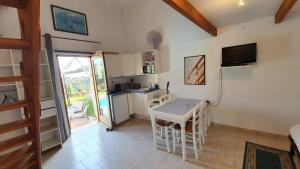 eine kleine Küche mit einem Tisch und einem TV in der Unterkunft Studio-mezzanine dans villa in Cagnes-sur-Mer