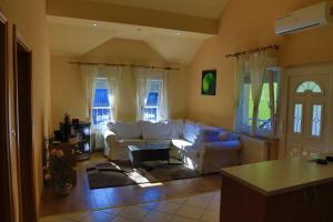 a living room with a white couch and windows at Apartments Crvena Jabuka in Ključ