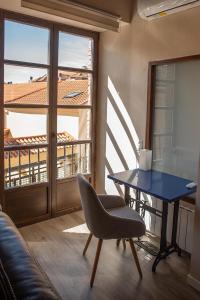 een woonkamer met een blauwe tafel en een stoel bij La Casona del Asno in Alcalá de Henares