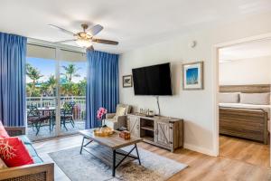 a living room with a tv and a couch at Sunrise Suites - Butterfly Nest #107 in Key West