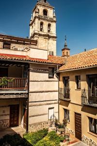 un antiguo edificio con una torre y una iglesia en La Casona del Asno, en Alcalá de Henares