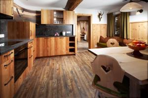 une cuisine avec des armoires en bois et un comptoir dans l'établissement Alpenpension Ettlerlehen Ferienwohnungen, à Ramsau bei Berchtesgaden