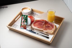 a tray with a sandwich and a glass of orange juice at Hotel Burlada in Burlada