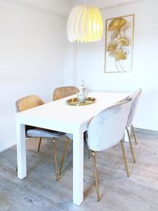 a white dining room table with chairs and a light fixture at Fuchsbau unterm Krönchen in Siegen