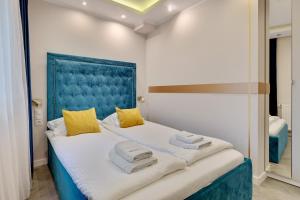 a bedroom with a large bed with a blue headboard at Dom & House - Apartments Waterlane Island in Gdańsk