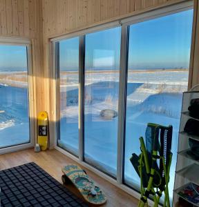 a room with windows and a skateboard on the floor at AITVARU TERASOS apartamentai pirmame aukšte su terasa į kanalą in Svenele