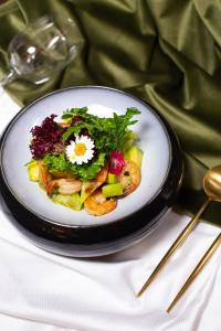 un piatto di cibo con insalata su un tavolo di ATB Grand Hotel a Atyraū