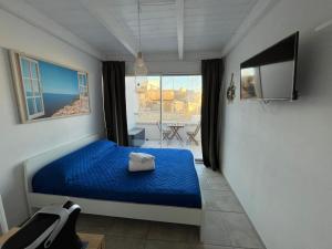a bedroom with a blue bed and a window at Romi' in Polignano a Mare