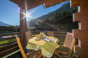 una mesa y sillas en el balcón de una casa en Résidence Améthystes A14 ski-in ski-out - Happy Rentals, en Chamonix-Mont-Blanc