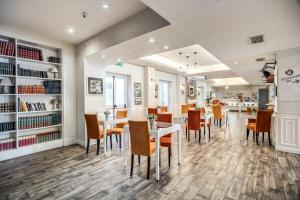 a dining room with tables and chairs and bookshelves at Hotel Isola Sacra Rome Airport in Fiumicino