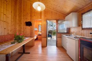 a kitchen with wooden walls and wooden flooring at Casa Rododendro in Barzio