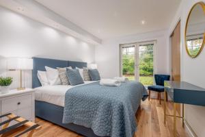 a bedroom with a blue bed and a window at Deluxe New Park Place Apartment - Parking in St. Andrews