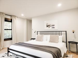Un dormitorio blanco con una cama grande y una ventana en Black Pearl Unit 1 - Lake Placid, Mirror Lake, en Lake Placid