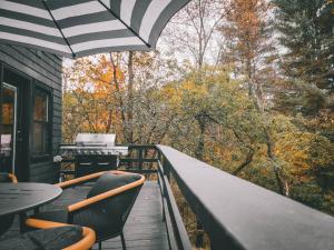 a balcony with chairs and a table and an umbrella at Black Pearl Unit 1 - Lake Placid, Mirror Lake in Lake Placid +5 photos