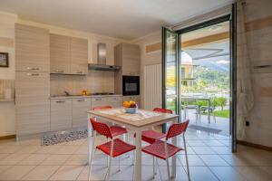 a kitchen with red chairs and a table with a view at Fior Di Loto in Sulzano