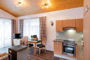 uma cozinha com uma mesa e uma sala de jantar em Ferienwohnung Heidi em Elmen