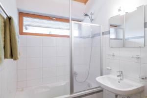 a white bathroom with a shower and a sink at Ferienwohnung Heidi in Elmen +38 photos