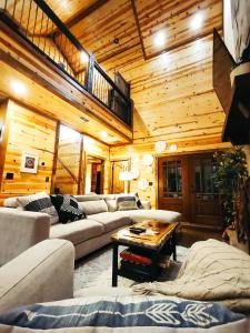 a living room with couches and a wooden ceiling at Fishers of Zen - Broken Bow Vacation Cabin in Broken Bow